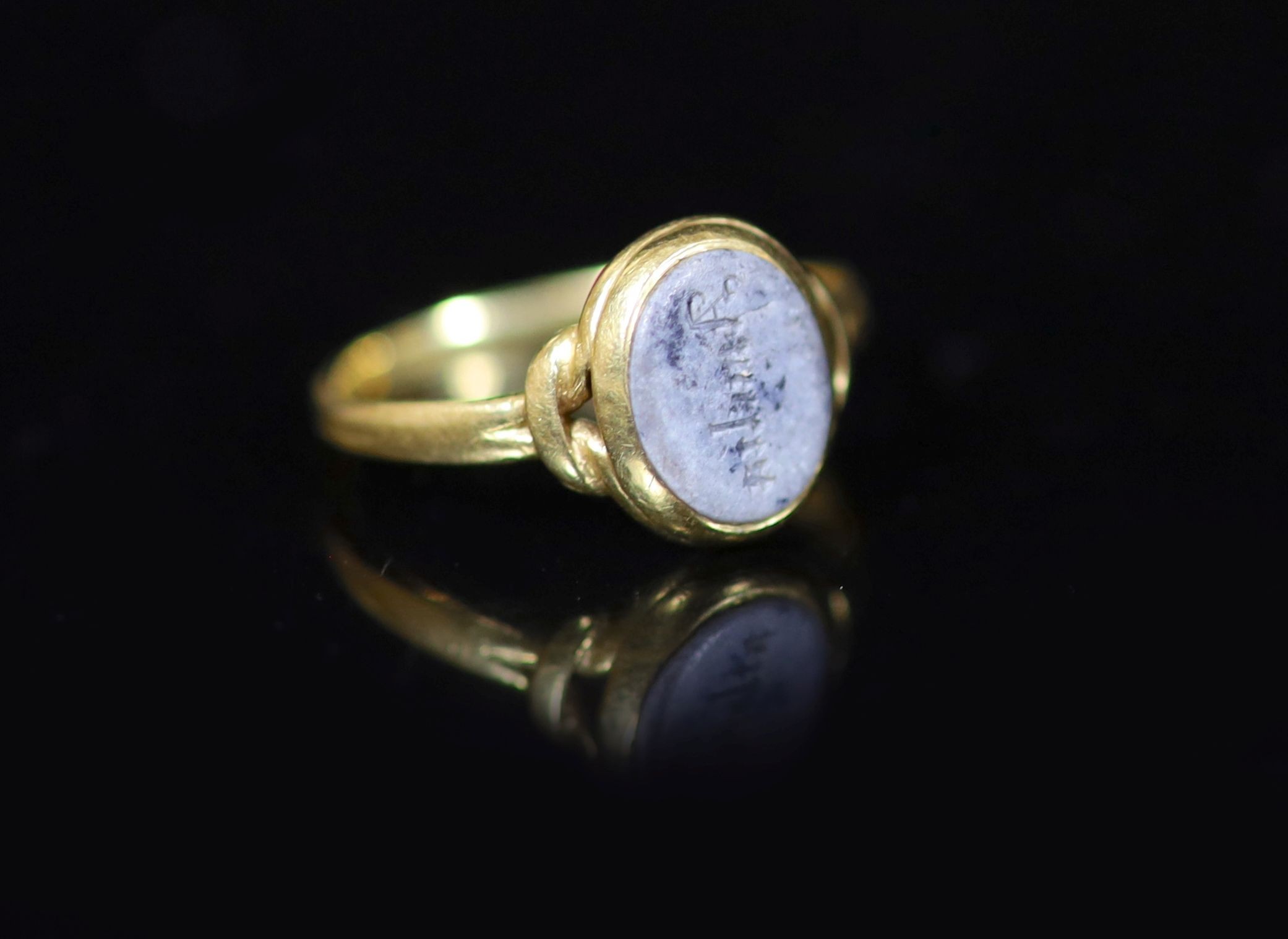 An antique gold and oval chalcedony set ring, carved with the name 'Amelia'